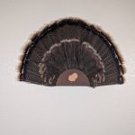 Kabash Outdoors American steel turkey fan display hanger. Fan holder is rustic brown with a turkey silhouette cutout. It is holding a beautiful turkey tail.